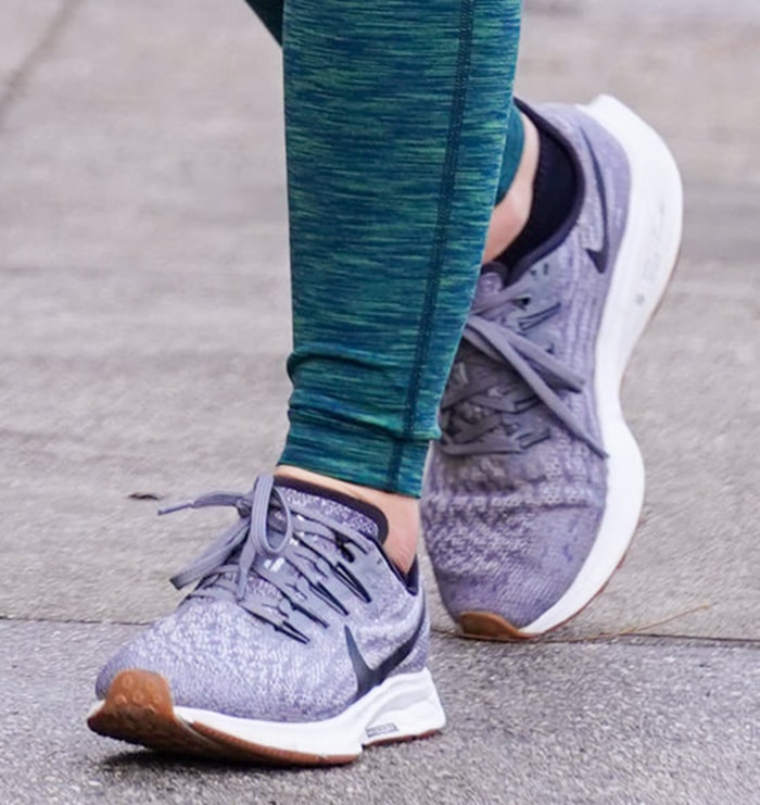 A close-up highlights Hale’s gray Nike Air Zoom Pegasus 36 sneakers, with their breathable mesh uppers, exposed Flywire cables, and white cushioned soles