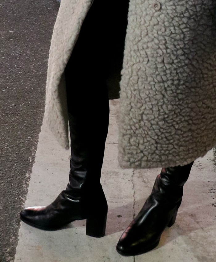 Hale’s Stuart Weitzman knee-high boots extend the clean black line of her leather trousers while their block heels add practical height