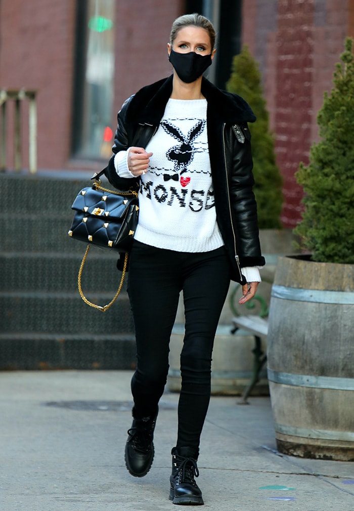 Nicky Hilton demonstrates her signature high-low approach to winter dressing by pairing rugged Prada Brixxen combat boots with a luxe Valentino Roman Stud bag and a Monse x Playboy knit