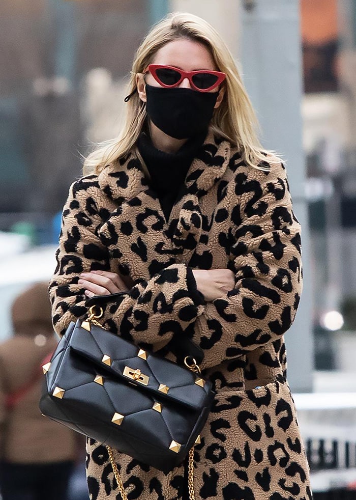 Nicky Hilton finishes her winter street-style look with an Apparis leopard-print coat, a Valentino Garavani Roman Stud shoulder bag, and red Le Specs x Adam Selman cat-eye sunglasses for a polished mix of classic and playful accessories