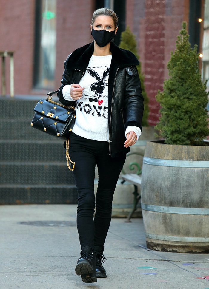 Nicky Hilton steps out in Manhattan wearing a Muubaa shearling biker jacket, a Monse x Playboy sweater, skinny black jeans, Prada Brixxen boots, and a Valentino Garavani Roman Stud shoulder bag