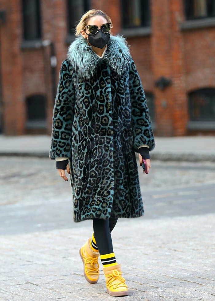 Olivia Palermo pairing a teal Cara Mila leopard-print coat with vibrant yellow Inuikii shearling sneaker boots and striped socks for a bold cold-weather look