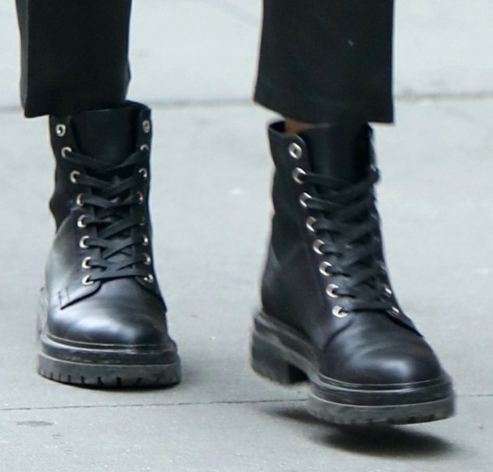 A close-up of Olivia Palermo's black Gianvito Rossi combat boots highlights their smooth leather construction, lace-up design, silver-tone eyelets, and sturdy lug soles, illustrating why the versatile style became a recurring favorite throughout her winter wardrobe