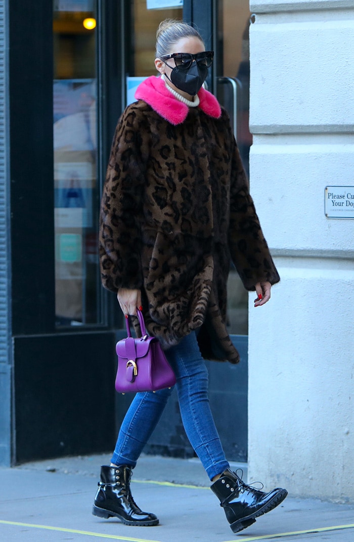Olivia Palermo brightens her winter wardrobe with a Cara Mila leopard-print coat trimmed in vibrant pink fur, carrying a purple Delvaux Brilliant bag and grounding the look with glossy Dior Rebelle Army combat boots