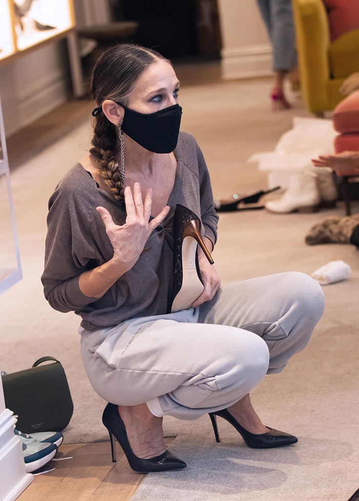 Sarah Jessica Parker pairs relaxed Pangaia cuffed track pants with black SJP “Hello Lover” pumps while helping customers at her New York City boutique