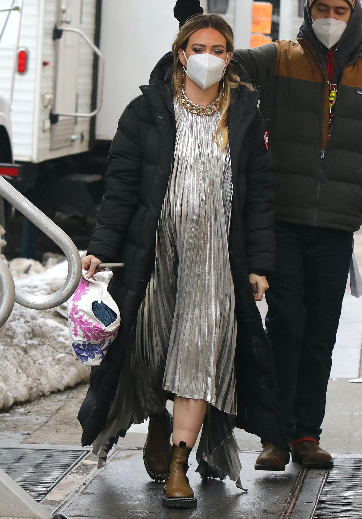 Hilary Duff balances glamour and practicality on the Younger set, layering a black Canada Goose Mystique parka over a silver pleated Givenchy chain-neck dress and finishing the look with Proenza Schouler Chelsea boots.