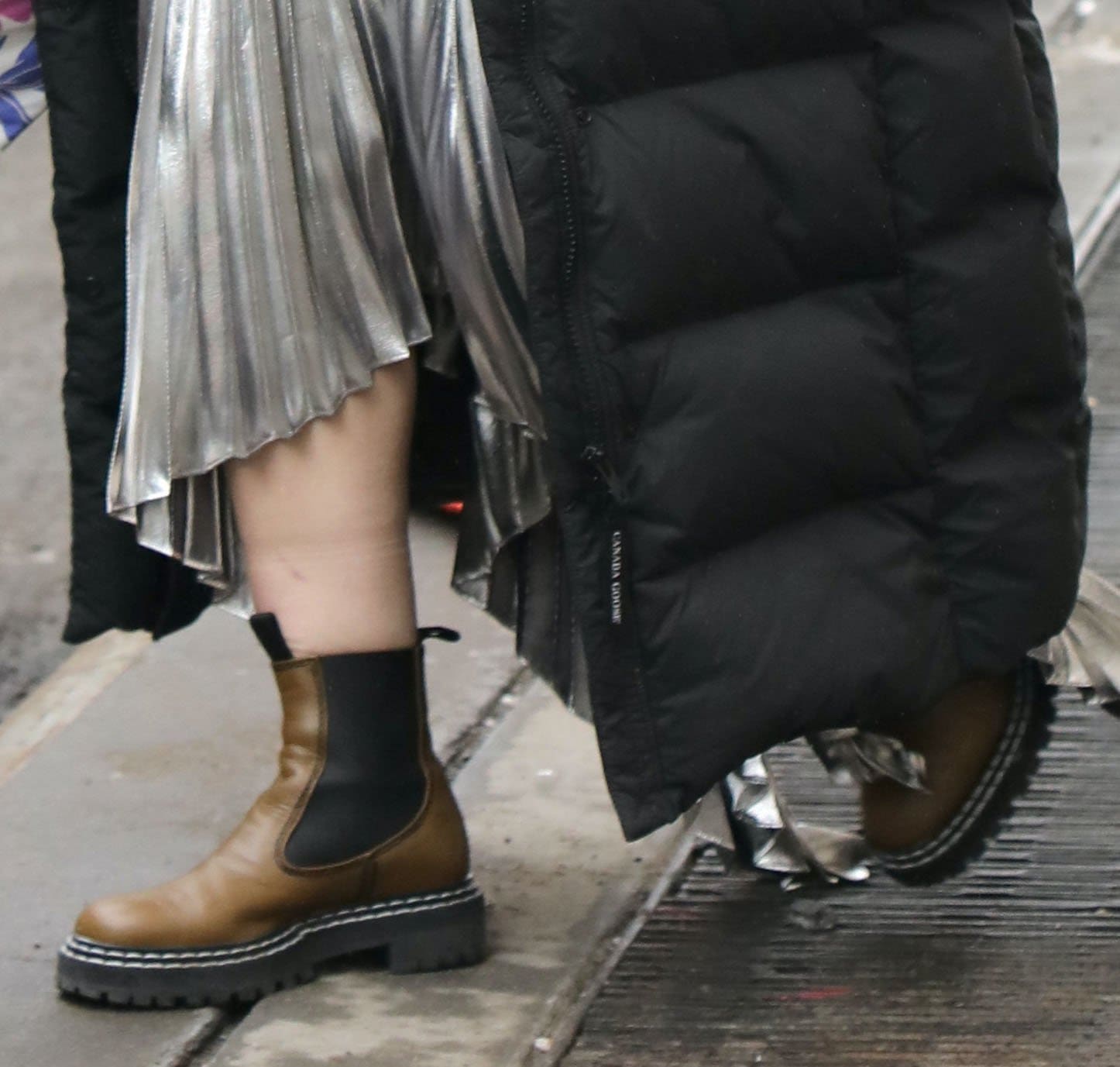 A close-up of Hilary Duff's Proenza Schouler Chelsea boots highlights their chunky lug soles, elastic side panels, and utilitarian silhouette, providing a grounded contrast to her shimmering Givenchy pleated dress