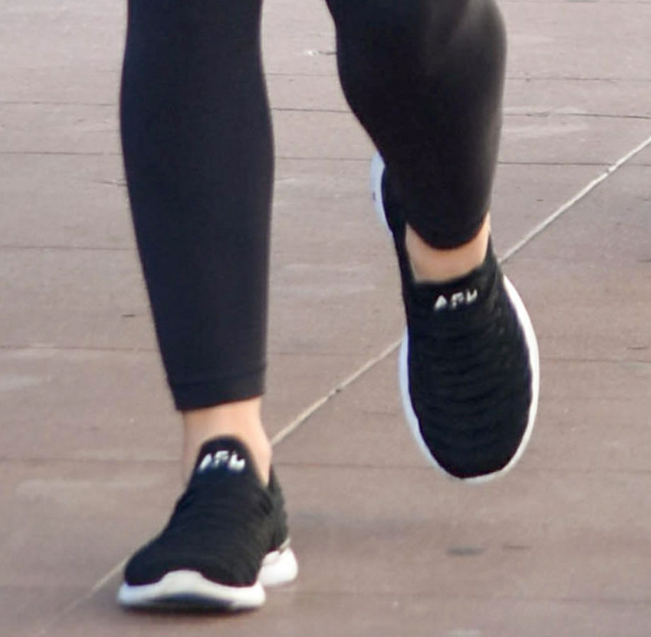 Lucy Hale completes her athleisure look with black APL TechLoom Wave sneakers, whose seamless knit upper can also be worn as a slip-on without laces