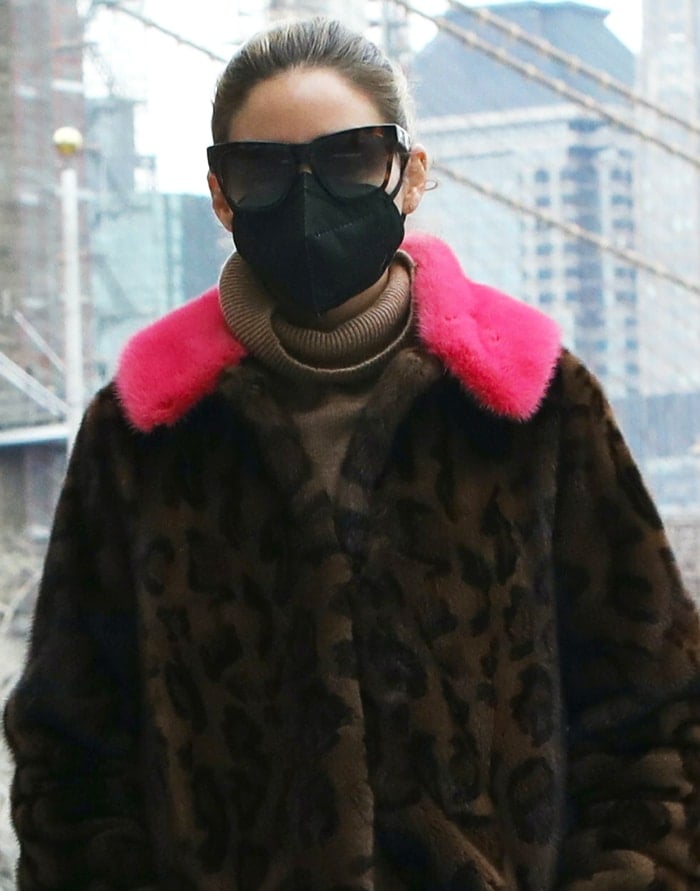 Olivia Palermo frames her brown leopard-print mink coat with a vibrant hot-pink fur collar, adding a bold pop of color to her neutral turtleneck and understated winter accessories