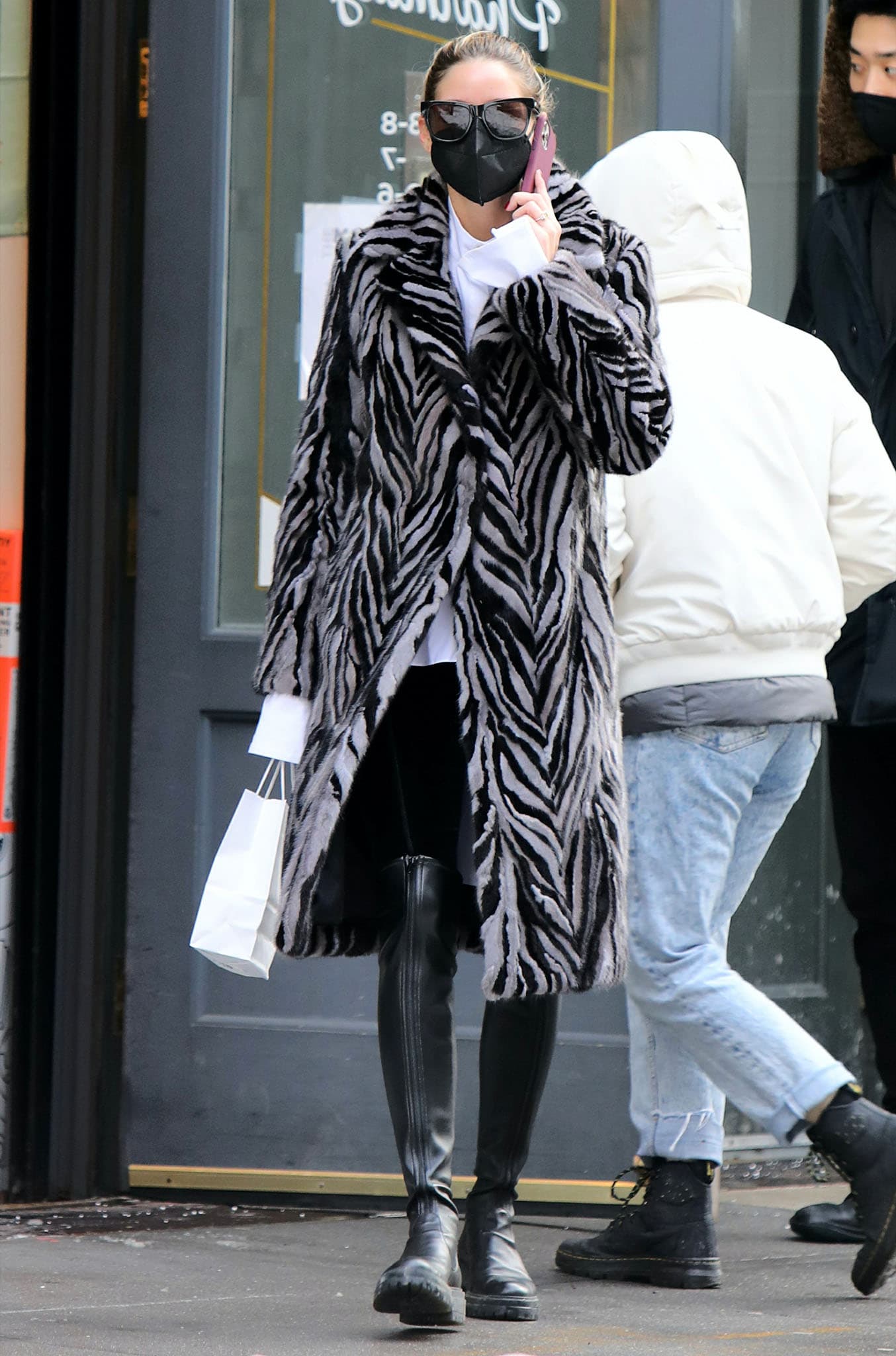 Olivia Palermo steps out solo in Downtown Manhattan on February 3, 2021, grounding her statement zebra-striped coat with sleek black over-the-knee leather boots that cut through the snow with polished ease