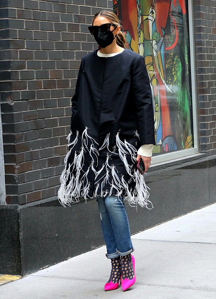 Olivia Palermo layers a feather-trimmed black coat over rolled-cuff jeans and finishes the unexpected winter look with hot pink Roger Vivier "Love Vivi" satin pumps and sheer polka-dot socks