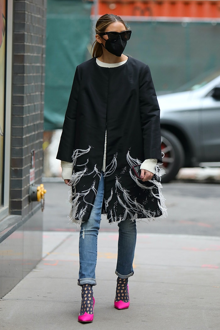 Olivia Palermo wearing a dramatic black Pologeorgis "Harlow" mink coat with feather-trim embroidery, cuffed jeans, and hot-pink pumps that instantly brighten the monochrome look
