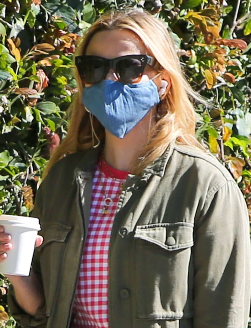 Reese Witherspoon keeps her accessories minimal with oversized black sunglasses and a denim face mask, letting her casual layers do the styling work