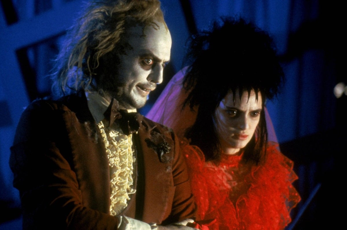 Michael Keaton as Betelgeuse and Winona Ryder as Lydia Deetz in Beetlejuice (1988), where Ryder’s red tulle wedding dress became one of Tim Burton’s most iconic costume moments
