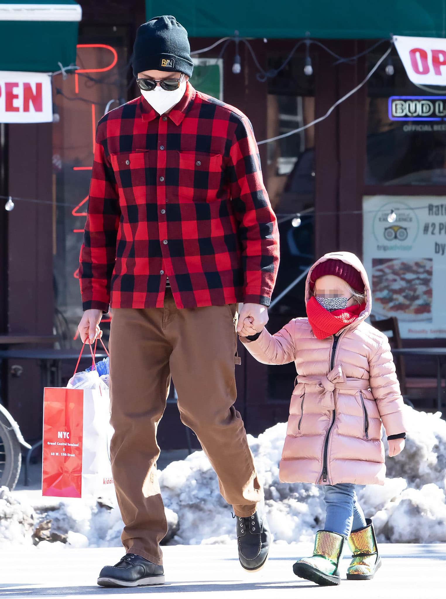 Bradley Cooper wears black leather moc-toe boots with brown pants while daughter Lea steps out in metallic rainbow boots