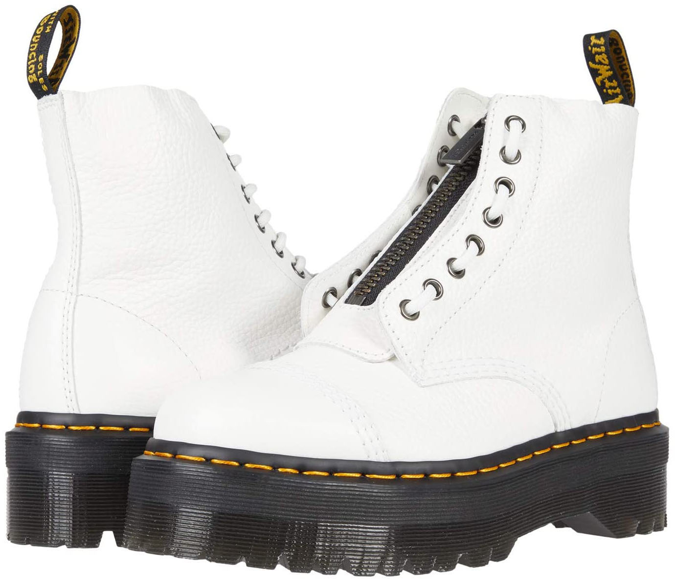The white leather Sinclair platform boots feature an 8-eye lace-up construction, removable jungle zipper, and signature yellow stitching atop a rugged air-cushioned sole