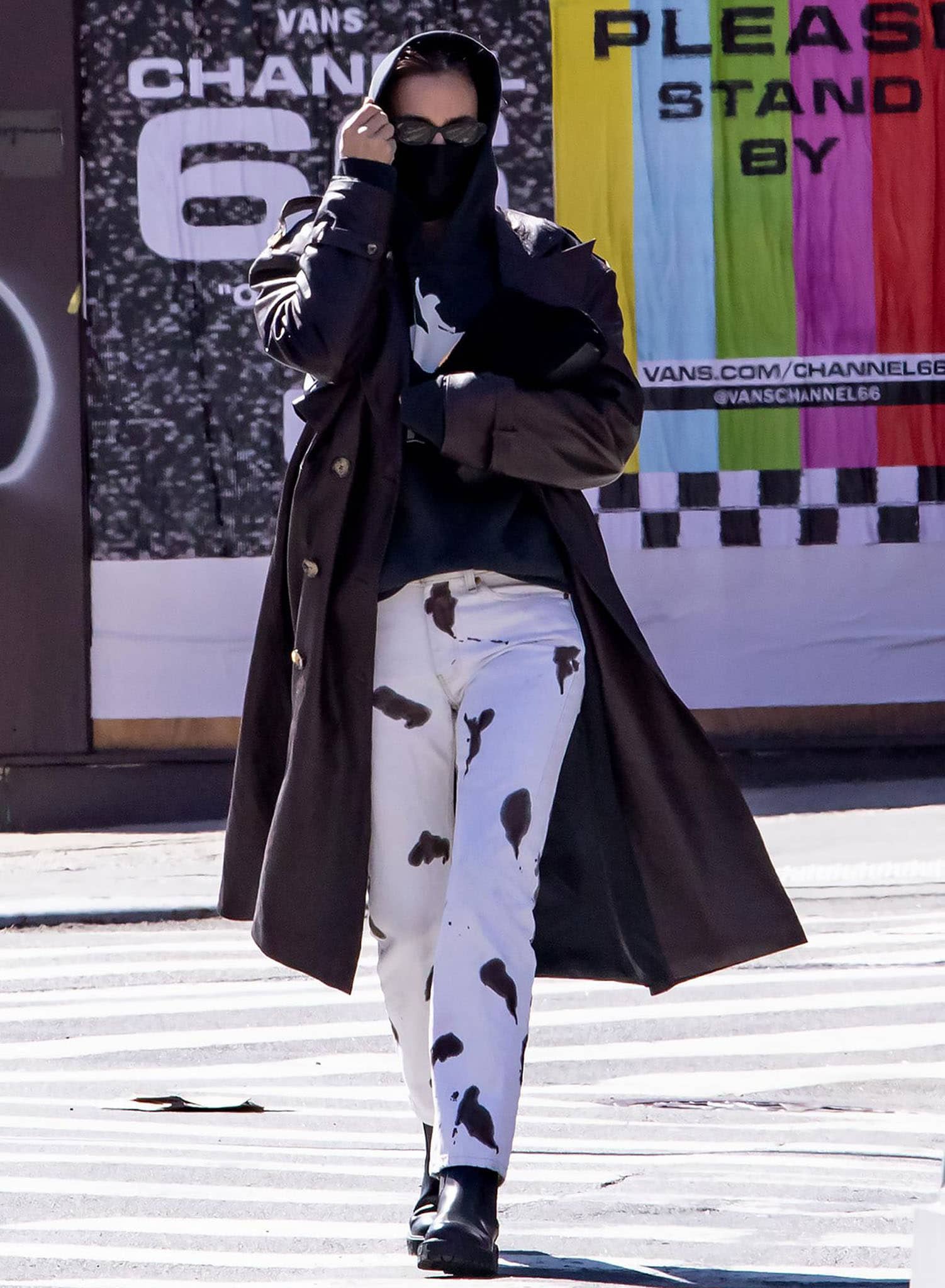 Irina Shayk pairs black Ferragamo Varsi Chelsea boots with spotted white Basket Case Gallery pants, a black logo hoodie, and a Bordeaux Magda Butrym leather coat