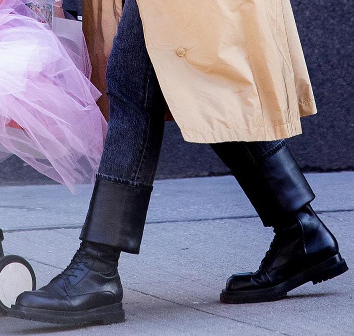 Irina Shayk’s Magda Butrym combat boots feature black leather uppers, lace-up fronts, inside zips, and thick ridged soles beneath her leather-cuff Burberry jeans