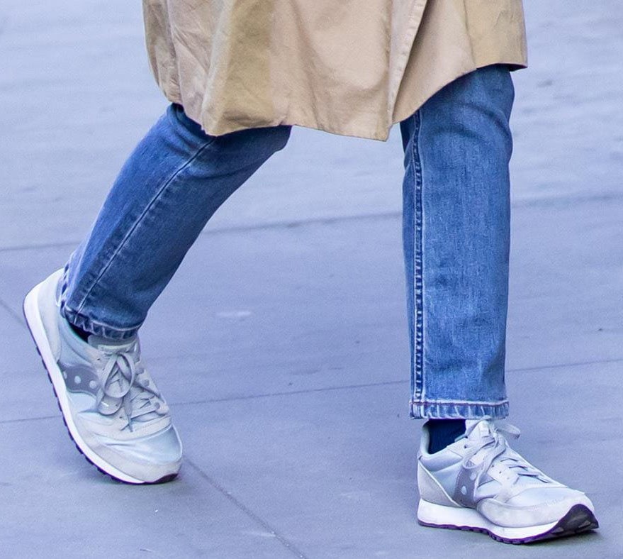 Katie Holmes finishes her off-duty look with retro Saucony Jazz 81 sneakers, their classic nylon-and-suede design adding a timeless athletic touch to her relaxed denim and trench coat ensemble