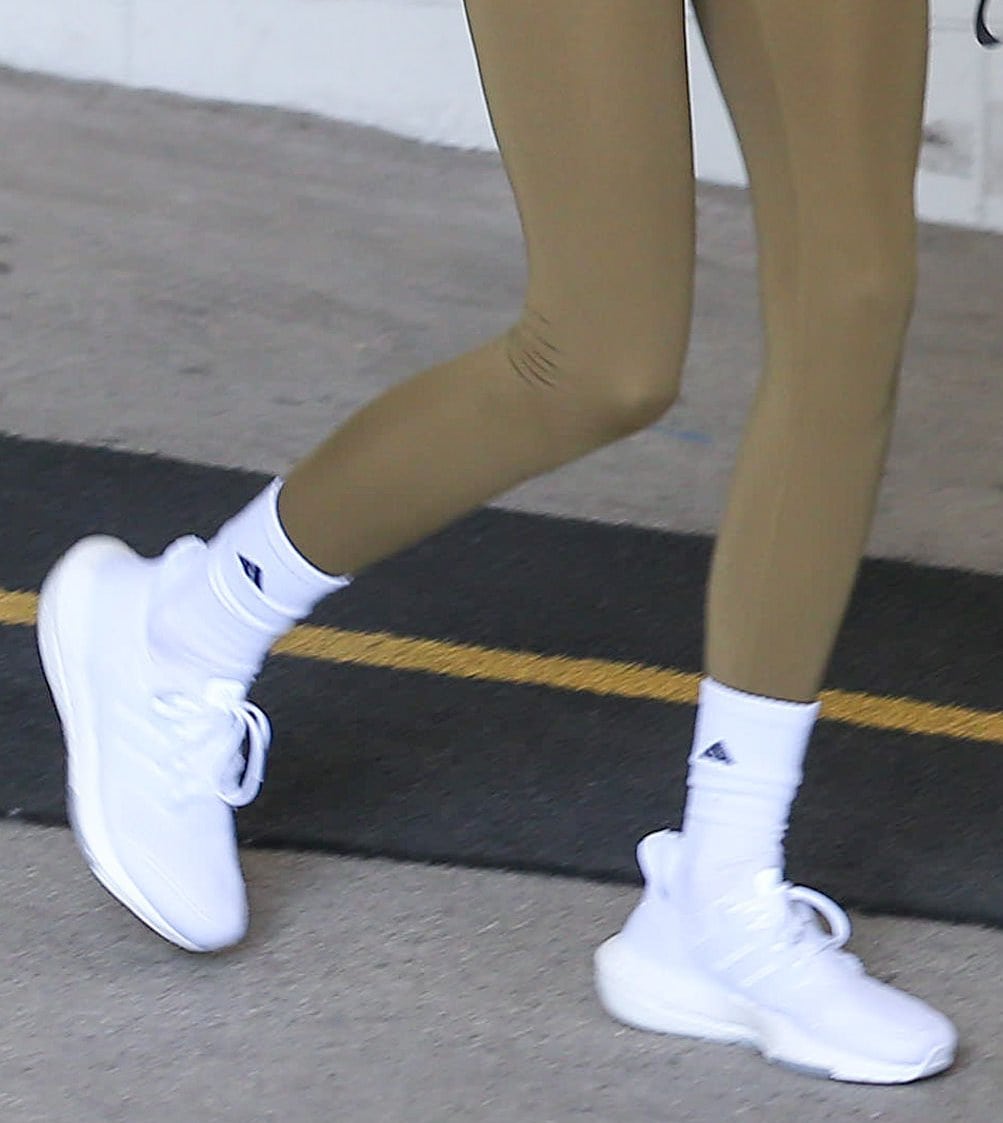 Kendall Jenner completes her olive workout look with white Adidas crew socks and Adidas Originals ZX 2K Boost sneakers