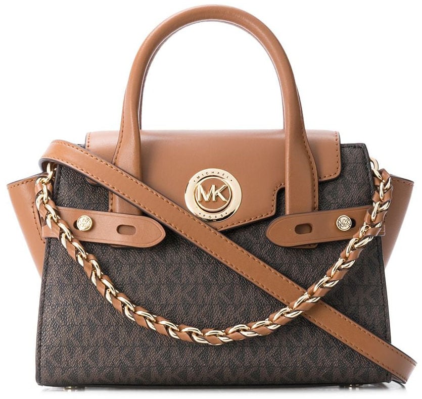 Easily identified by its trapeze shape, the Michael Kors Carmen belted bag can be carried using the top handles or the crossbody strap