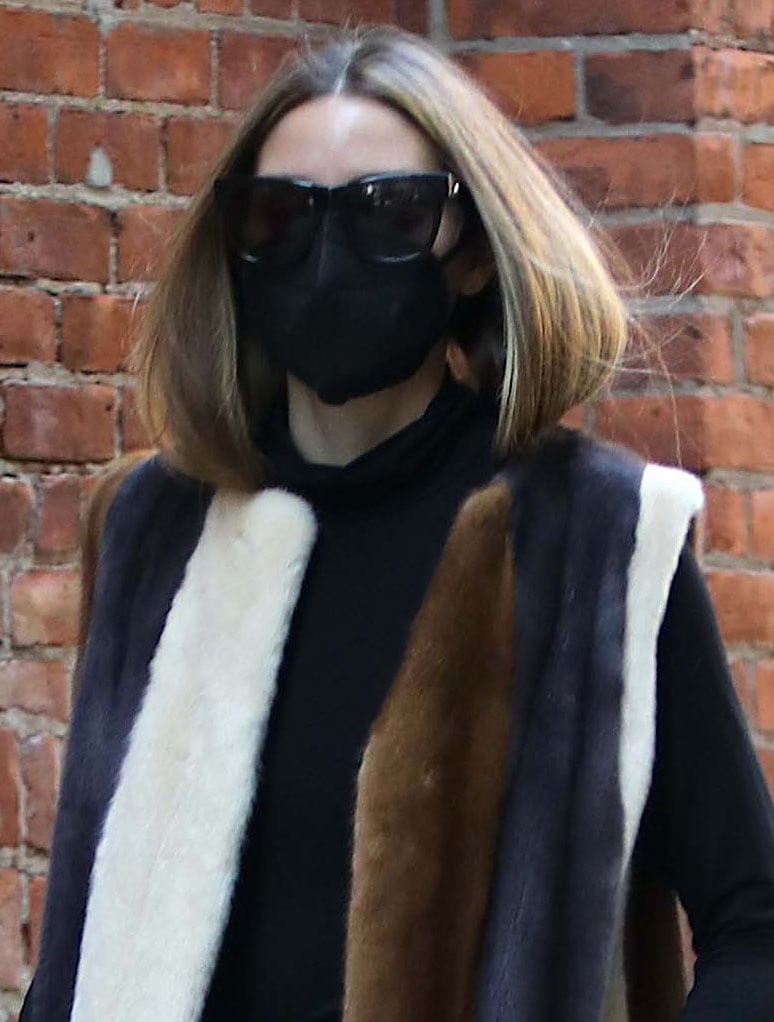 Olivia Palermo shields her eyes behind oversized Le Specs Air Heart sunglasses, adding a chic touch to her cozy winter street style
