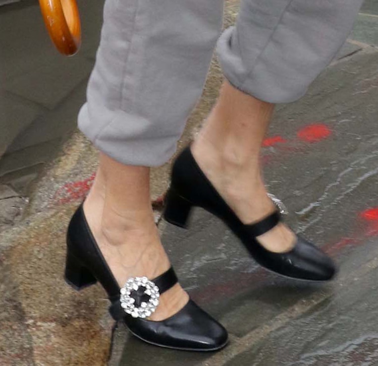 Sarah Jessica Parker completes her embroidered coat and gray track pants with black ‘Celine’ Mary Jane pumps featuring sparkling crystal-encrusted buckle straps