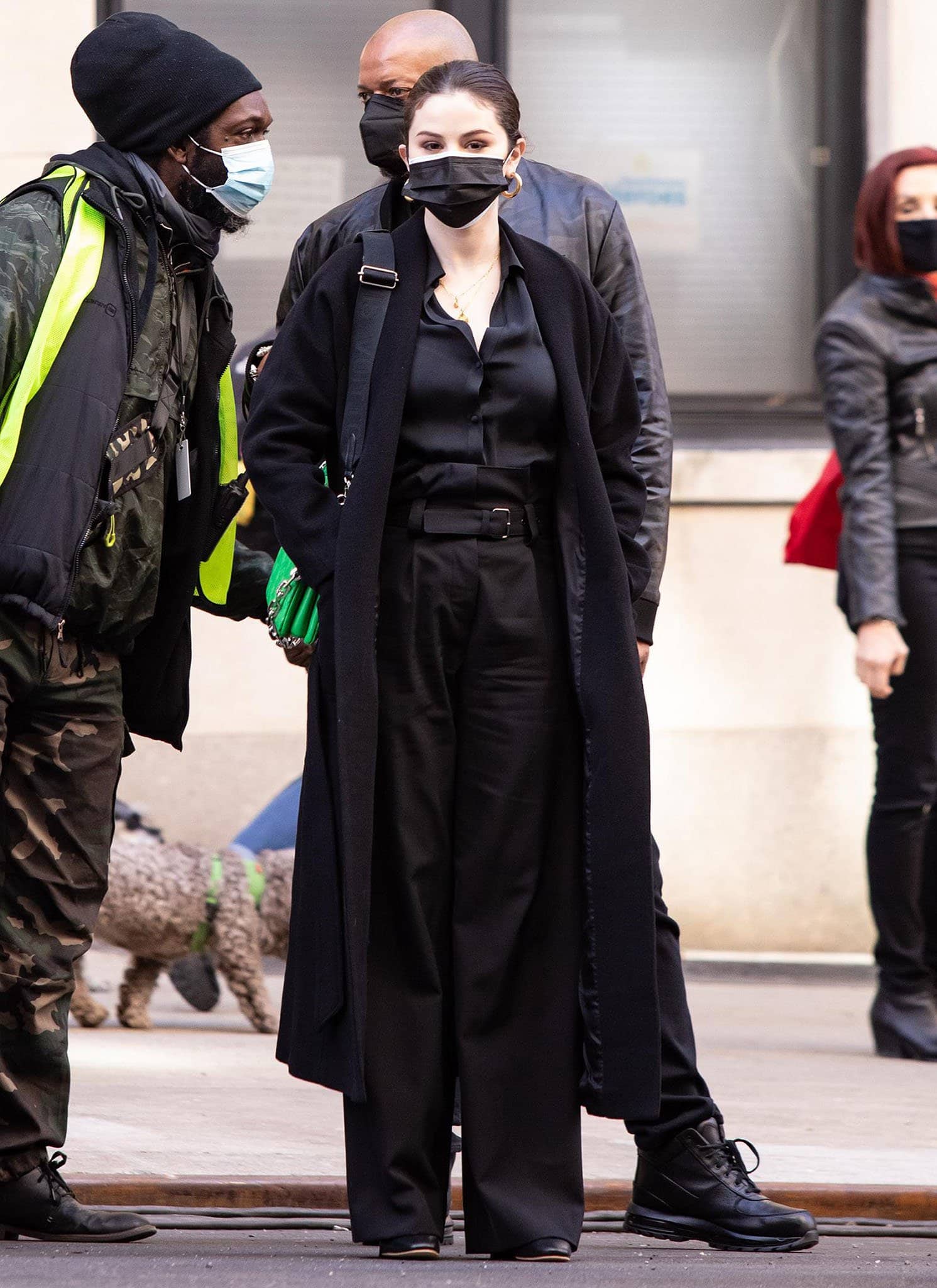 Selena Gomez pairs her sleek all-black filming outfit with a vibrant green Louis Vuitton Coussin PM crossbody bag, adding a bold pop of color while on the Only Murders in the Building set in New York City