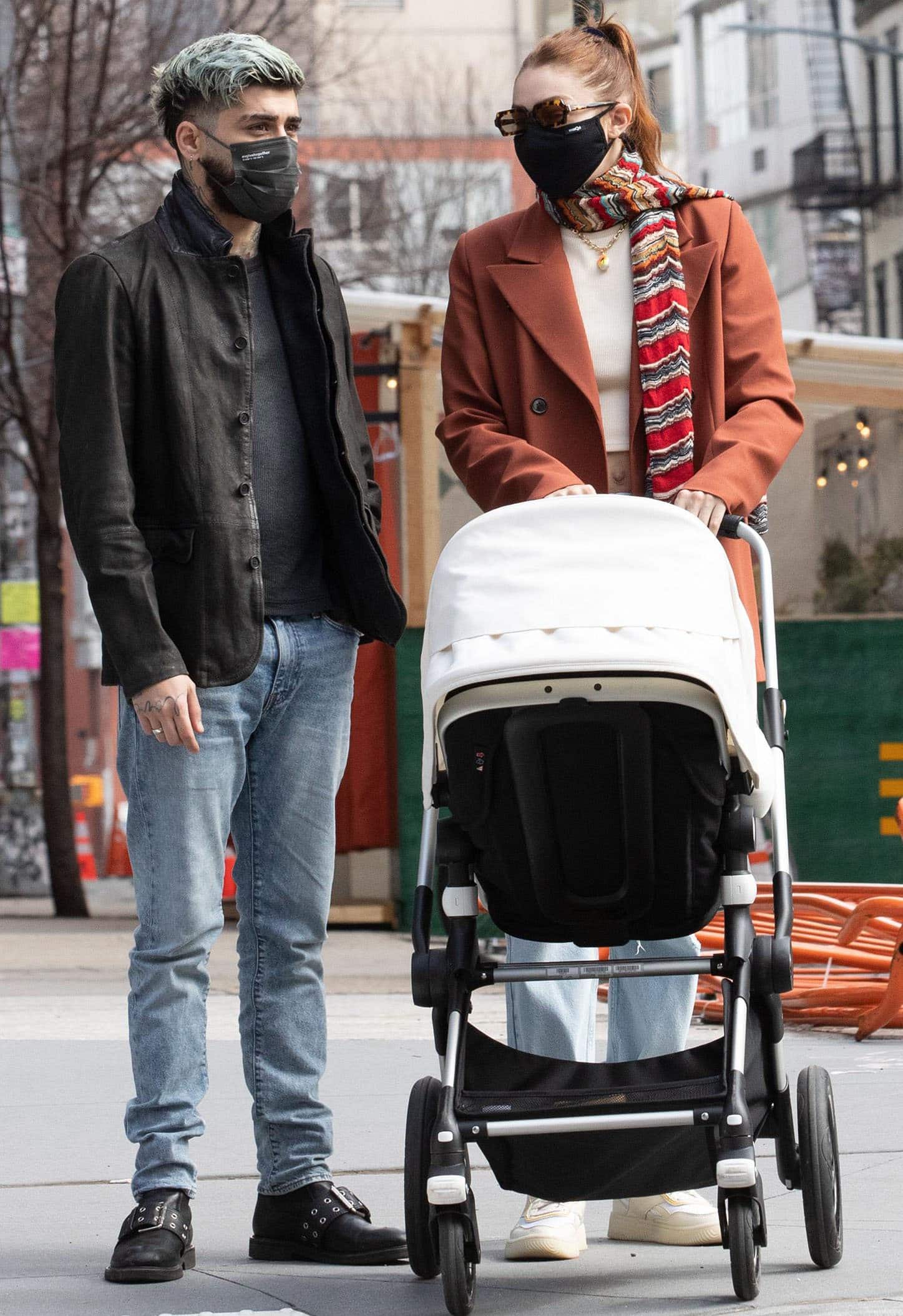 Zayn Malik and Gigi Hadid step out with daughter Khai in New York City on March 25, 2021, pairing relaxed denim and statement outerwear with Reebok x Victoria Beckham Dual Court II sneakers and hardware-trimmed leather boots
