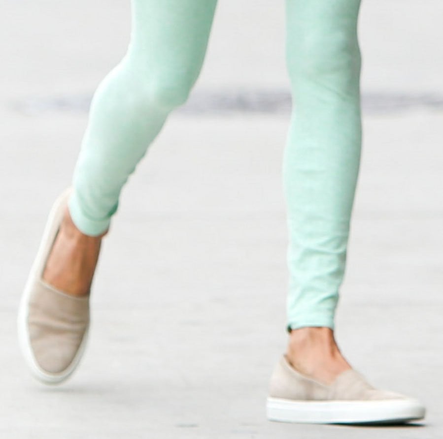 Alessandra Ambrosio pairs mint-green Alo leggings with neutral Common Projects slip-on sneakers, keeping her Pilates-ready look understated and streamlined