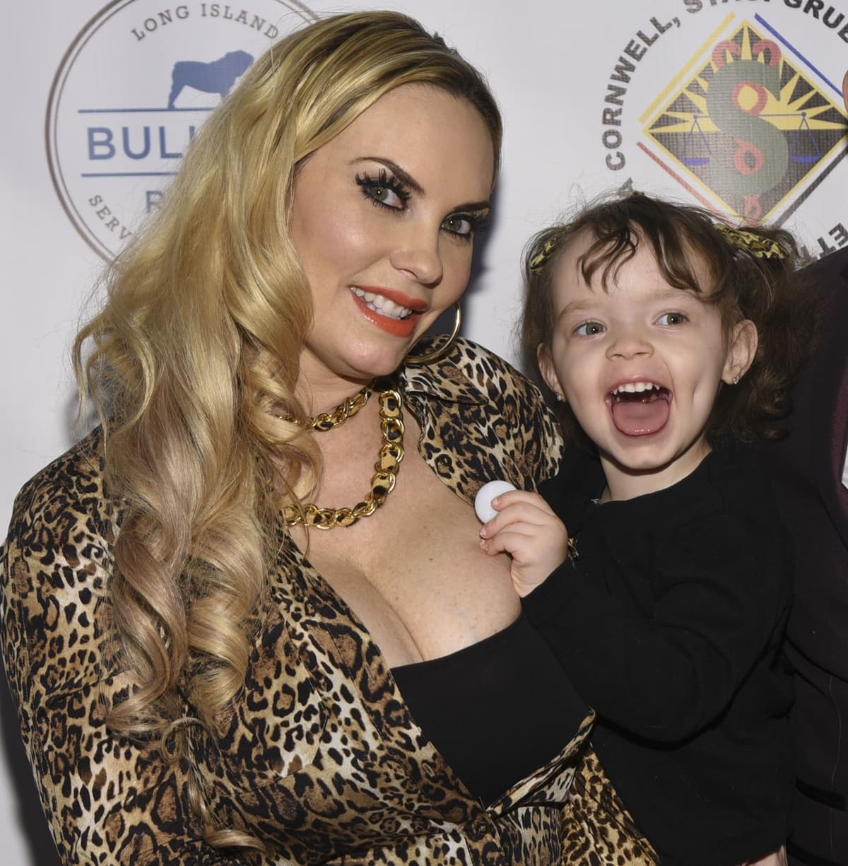 Coco Austin beams in a plunging leopard-print ensemble with chunky gold jewelry as she shares a joyful moment with her daughter Chanel Nicole Marrow in 2018