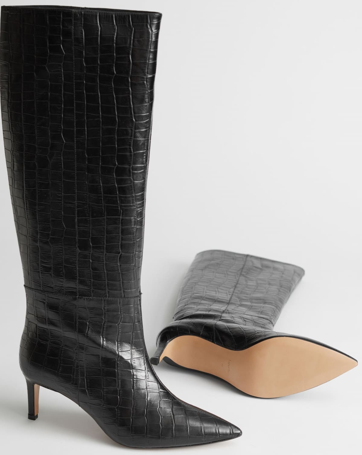 Step into the '90s revival with Other Stories' croc-embossed leather knee-high boots, featuring sleek stiletto heels and a chic pointed silhouette, perfect for any contemporary wardrobe
