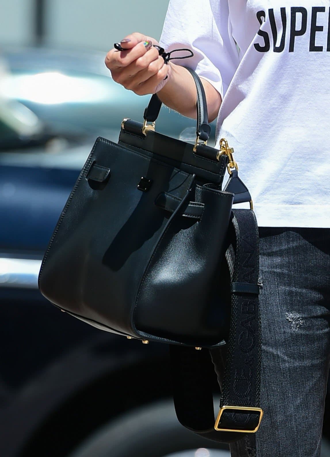 Heidi Klum carries a black Dolce Gabbana “Sicily” handbag, its structured silhouette and polished leather finish adding a refined edge to her off-duty look