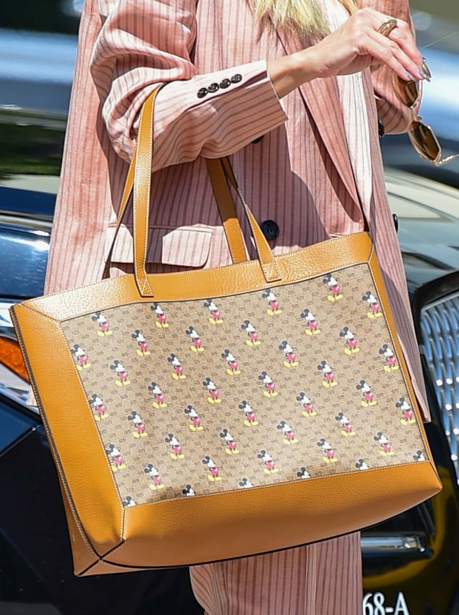 Heidi Klum carries a Gucci x Disney tote, the signature GG monogram canvas playfully reimagined with allover Mickey Mouse motifs and warm tan leather trims