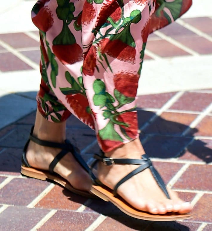 Heidi Klum grounds her breezy floral look with K.Jacques St. Tropez “Cedre” sandals, the flat leather silhouette defined by slim, crisscross straps and a minimalist sole that keeps the focus on effortless, sunlit ease