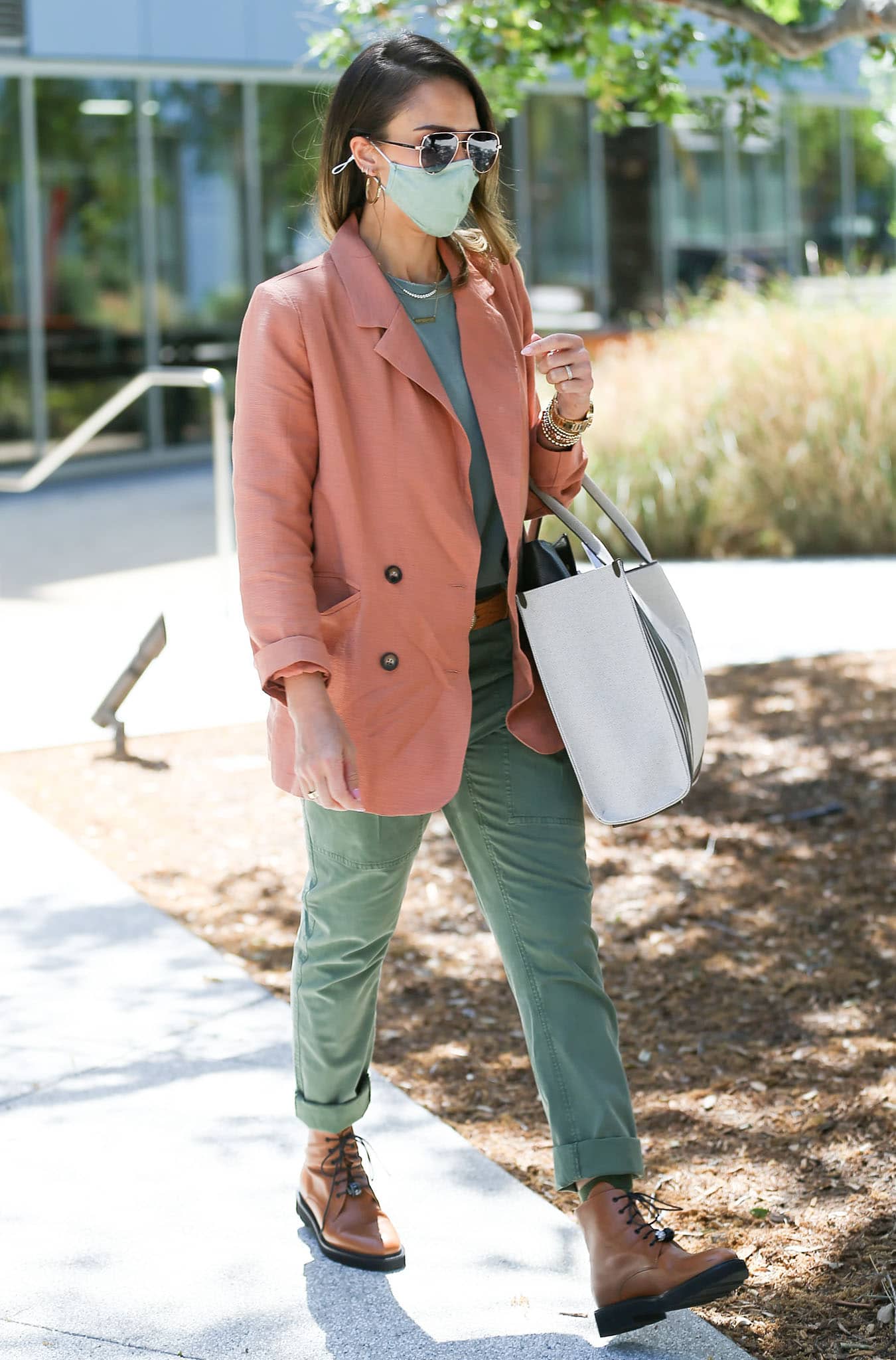 The muted peach-and-olive palette keeps Jessica Alba’s business-casual outfit relaxed and approachable while the chunky leather boots add structure and contrast