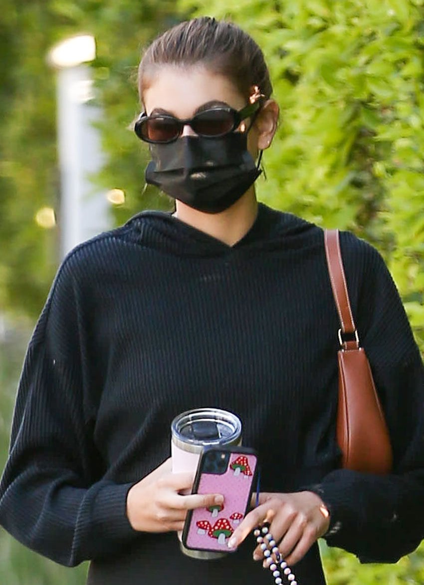 Kaia Gerber keeps it low-key with a sleek high ponytail, shielding her face behind oval sunglasses and a black mask for an effortlessly cool off-duty moment