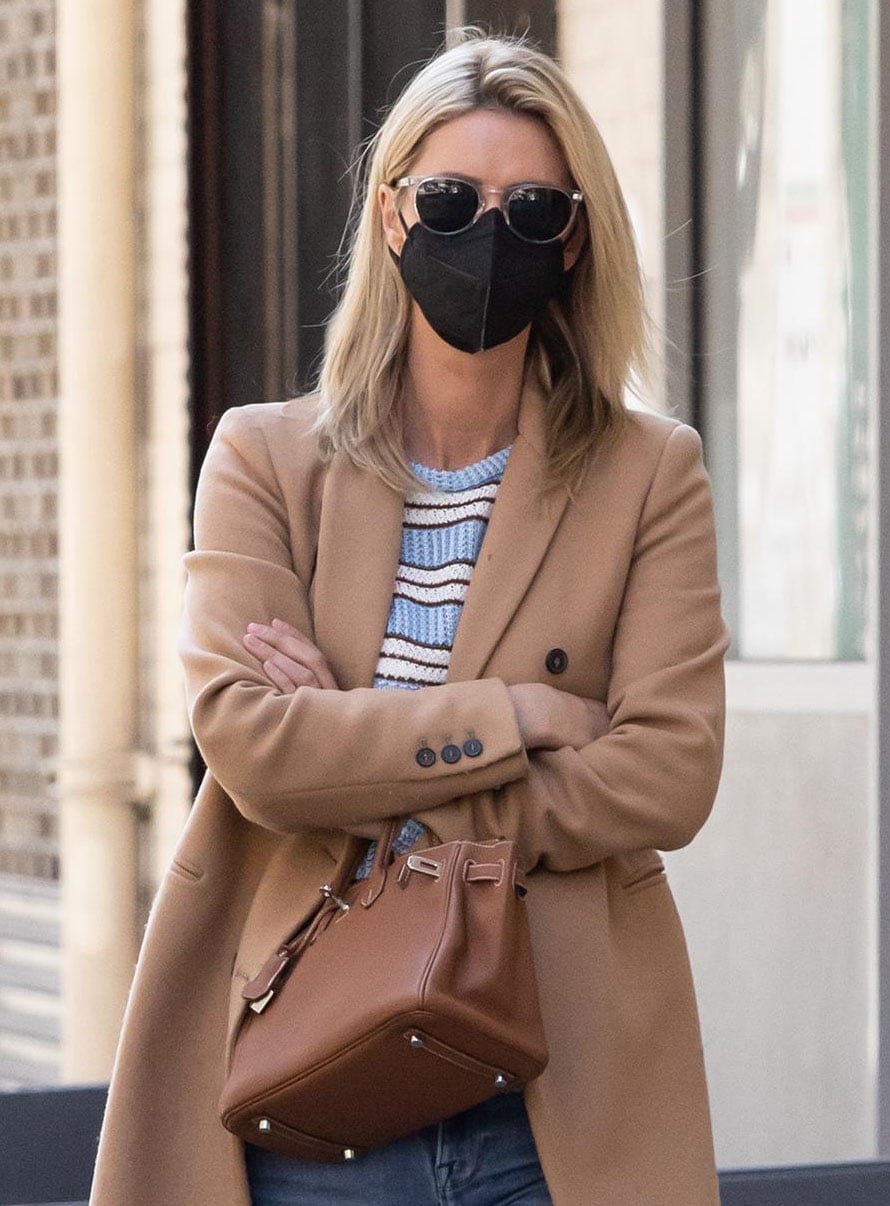 Nicky Hilton completes her off-duty look with retro sunglasses and a tan Hermès Birkin bag, echoing the warm neutral tone of her tailored camel coat