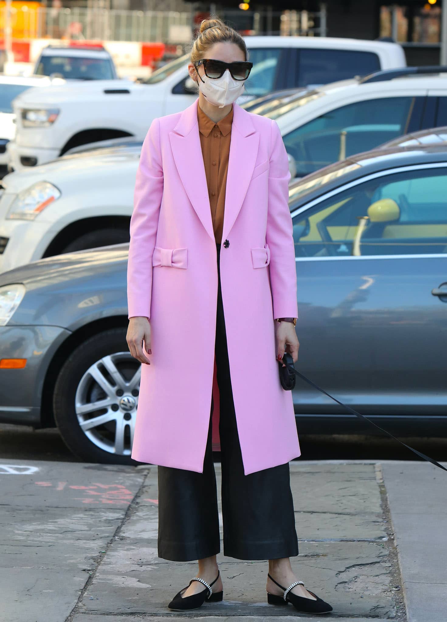 Olivia Palermo wears a petal-pink Smythe coat over a rust shirt and black wide-leg leather trousers with crystal slingback flats