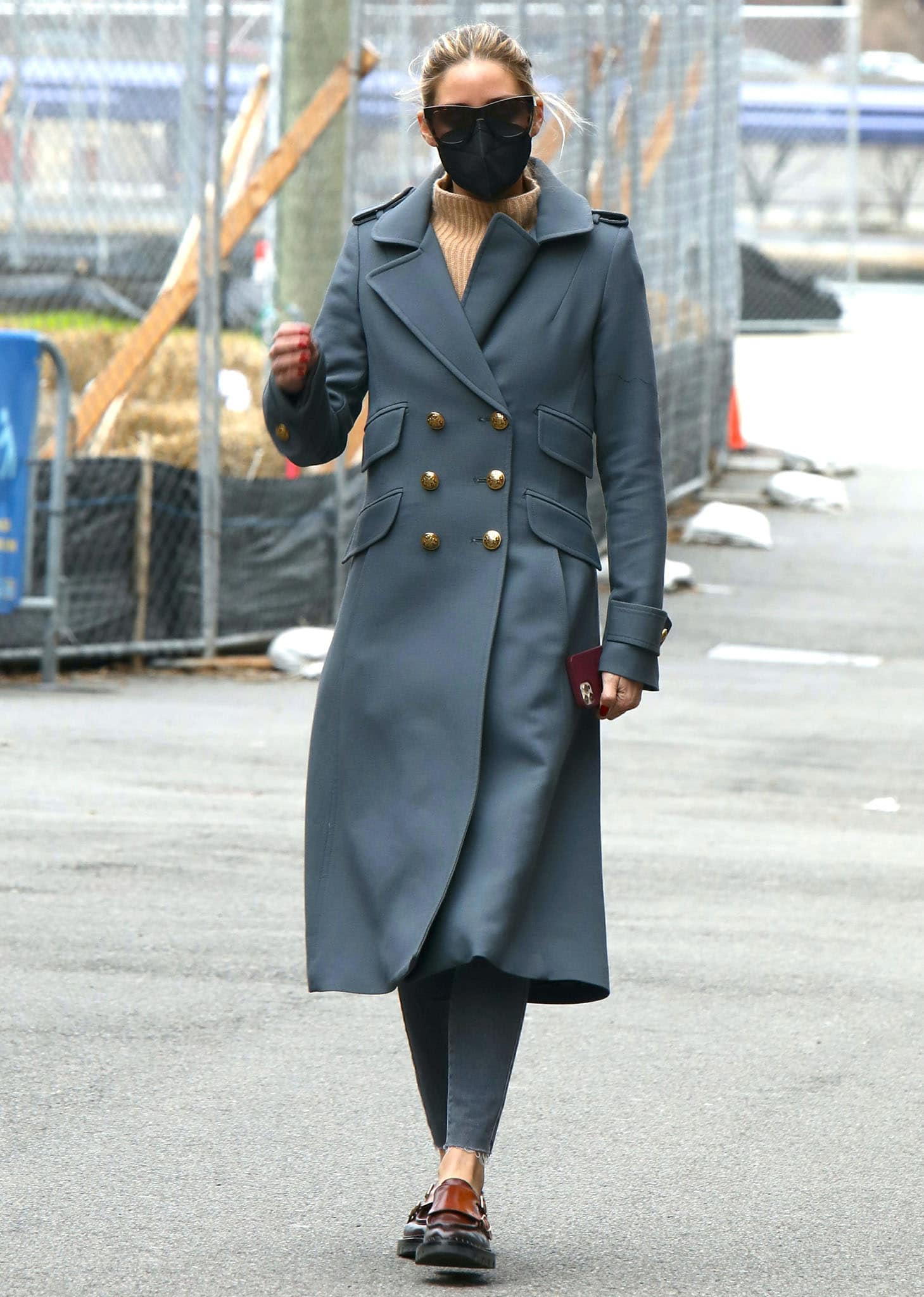 Olivia Palermo wears a blue-gray Smythe Birkin double-breasted coat with gray skinny jeans and Santoni monk-strap loafers in Brooklyn