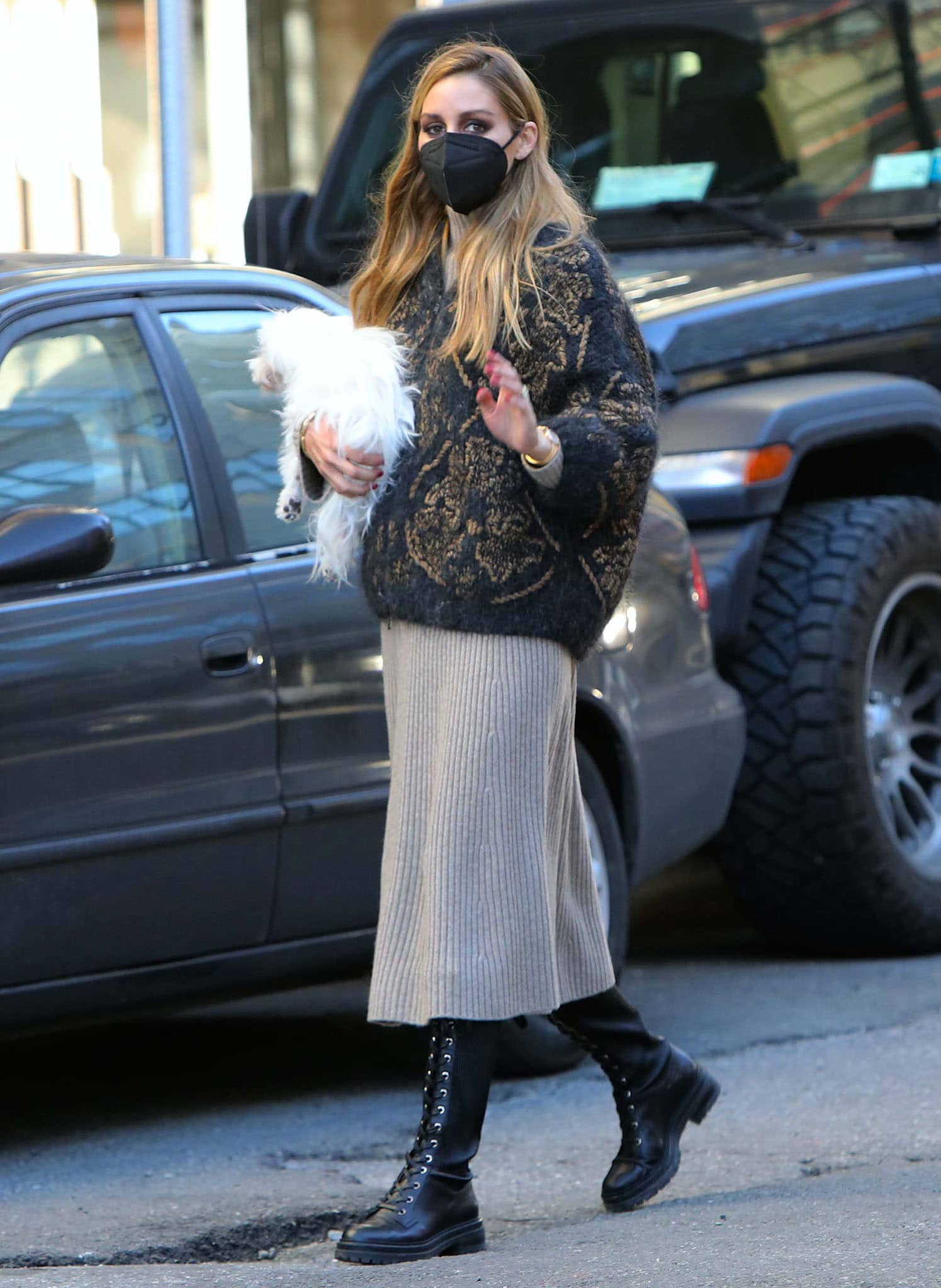 Olivia Palermo styles a gray ribbed midi dress with a navy Brunello Cucinelli cardigan and knee-high combat boots