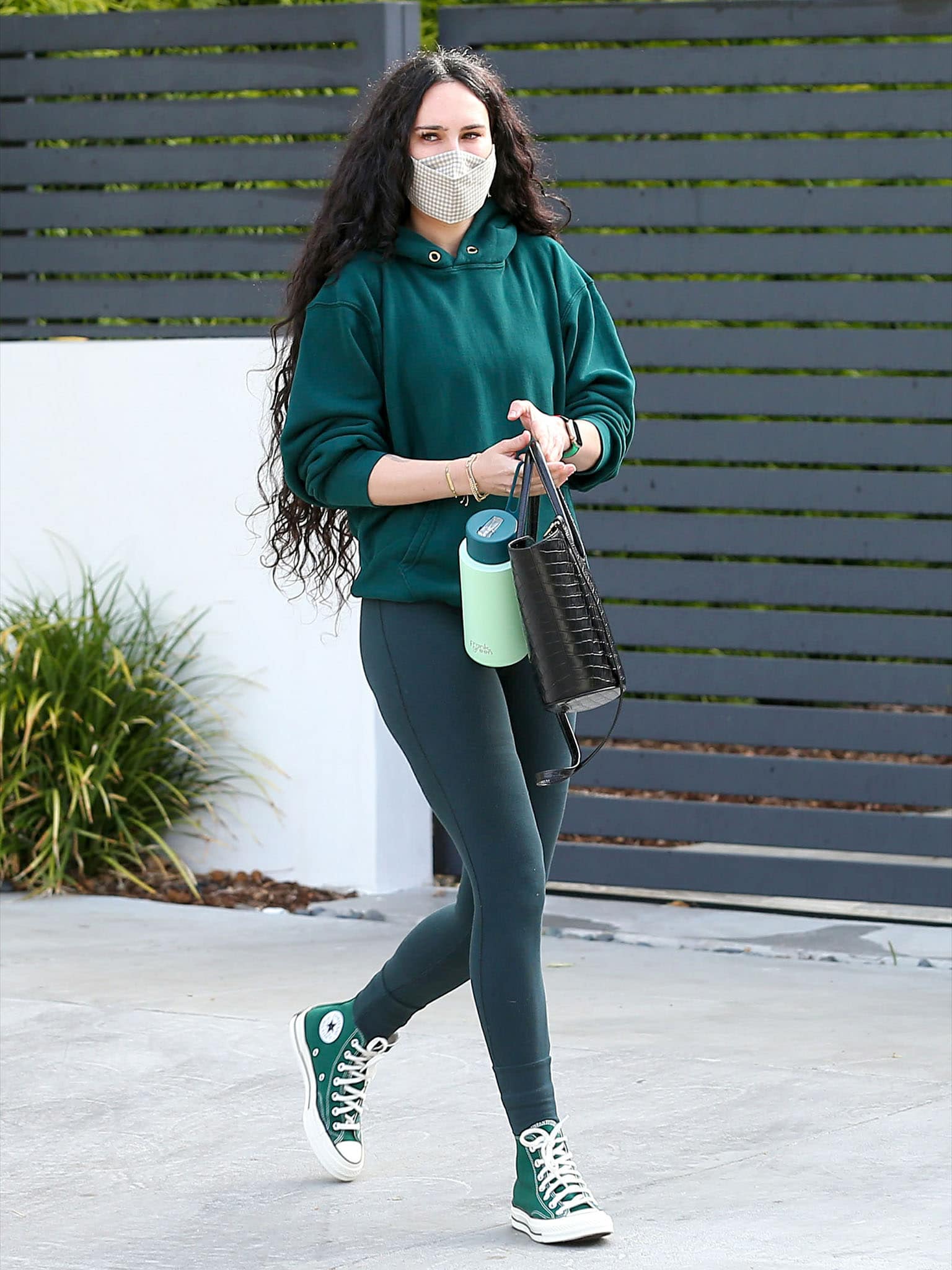 Rumer Willis embraces a monochrome athleisure look in a green hoodie and matching leggings, finishing the workout outfit with Amazon Green Converse Chuck Taylor high-top sneakers