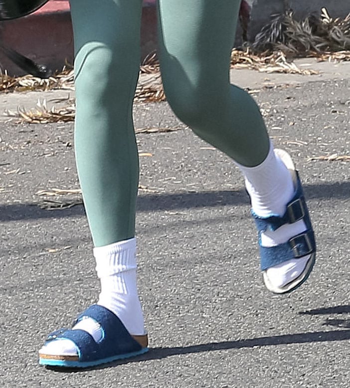 Rumer Willis pairs white crew socks with blue suede Birkenstock Arizona sandals, embracing the laid-back post-workout styling trend