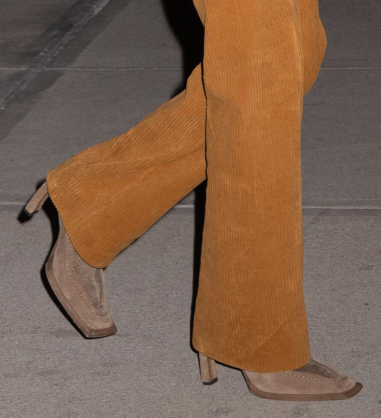 Bella anchors her retro outfit with understated square-toe suede boots, proving quiet footwear can be just as impactful as statement fashion