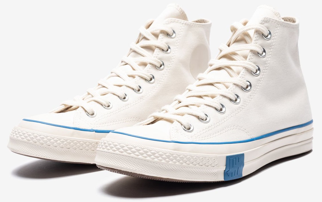 The Converse x Undefeated Chuck 70 Hi "Parchment" strips away the traditional ankle patch, relying on subtle blue accents and minimalist branding for its distinctive look