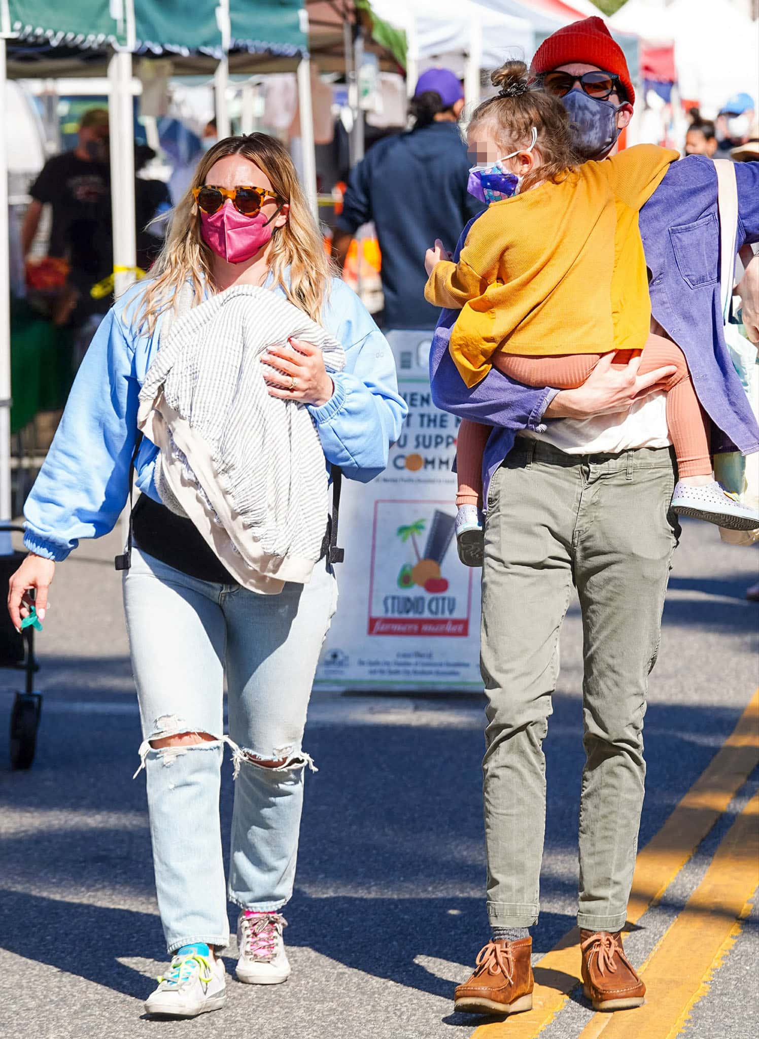Hilary Duff pairs distressed Agolde jeans with mismatched Golden Goose “Twenty” sneakers during a family farmers market outing