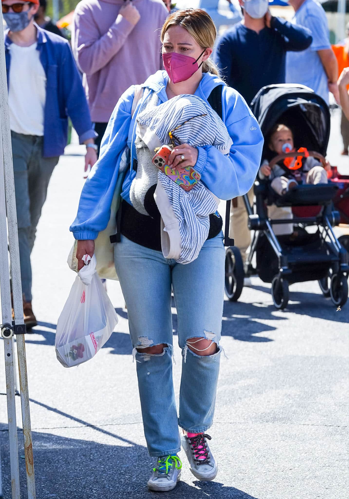 Hilary Duff’s powder-blue Alo Yoga hoodie provides a soft backdrop for the bright, deliberately mismatched details of her limited-edition Golden Goose sneakers