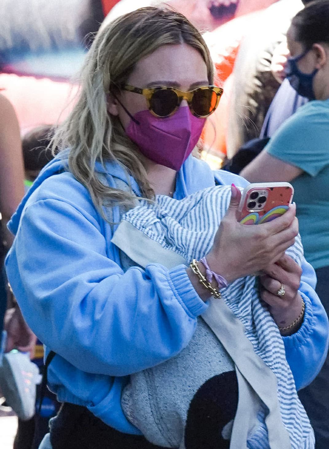 Oliver Peoples Merrivale sunglasses and a pink Maskc KN95 mask complete Hilary Duff’s casual accessories while she carries newborn daughter Mae