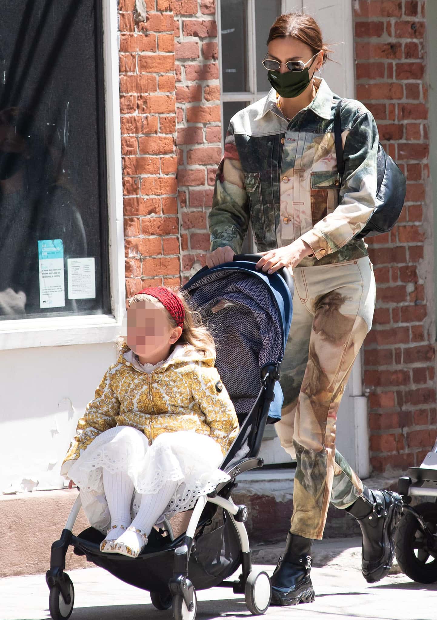 Irina Shayk drops her daughter off at school on April 23, 2021, wearing Renaissance-inspired Vivienne Westwood denim co-ords paired with chunky Burberry monogram ankle boots for an edgy finish