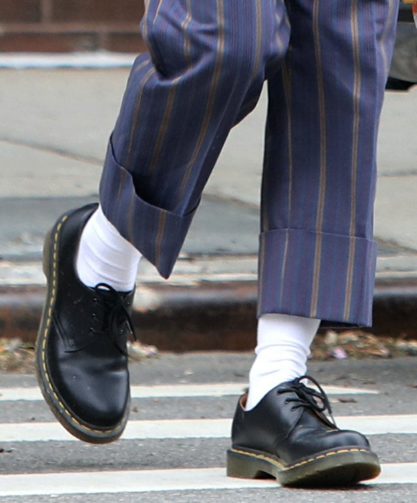 The cropped hem and exposed socks spotlight the Dr. Martens 1461’s clean three-eye silhouette and signature yellow welt stitching in motion
